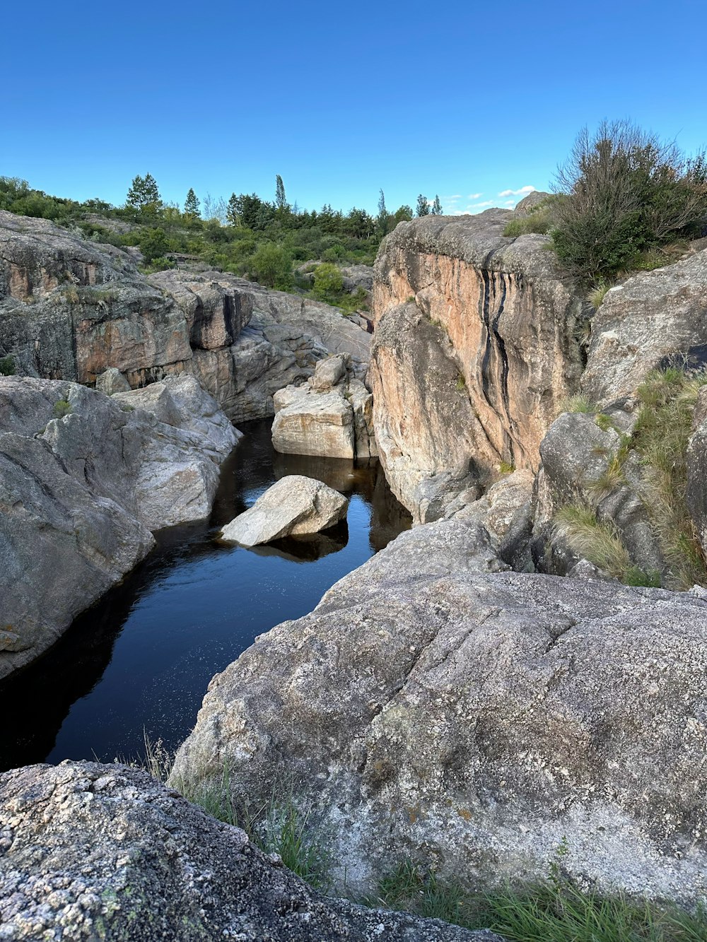a small pool of water surrounded by large rocks