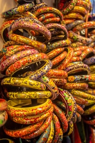 a bunch of colorful bracelets are stacked on top of each other