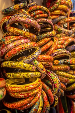 a bunch of colorful bracelets are stacked on top of each other