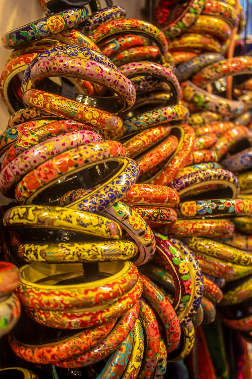 a bunch of colorful bracelets are stacked on top of each other