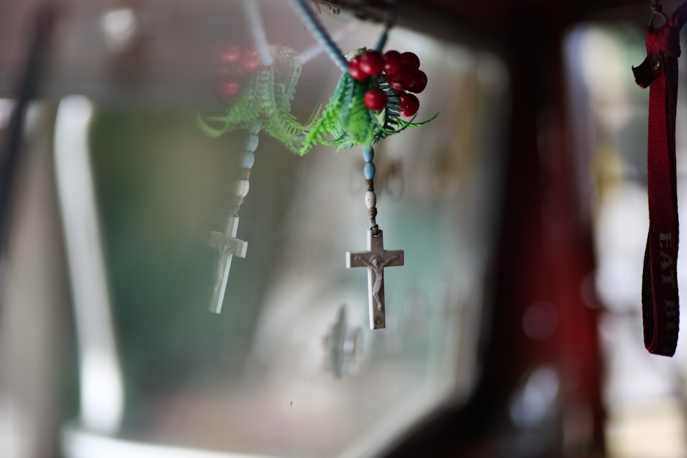 a close up of a cross hanging from a window