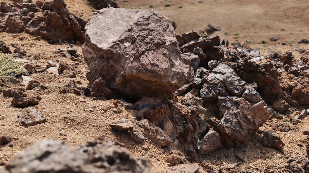 a large rock sitting on top of a dirt field