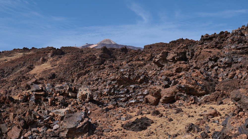 a rocky hill with a mountain in the background