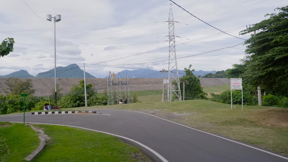 a winding road with power lines in the background