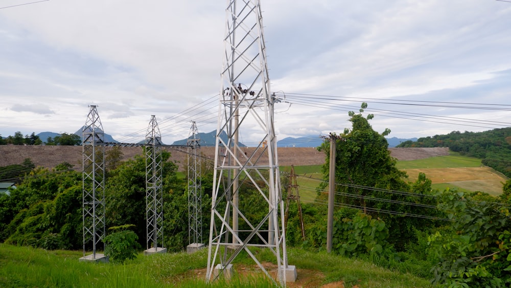 a tall metal tower sitting on top of a lush green hillside