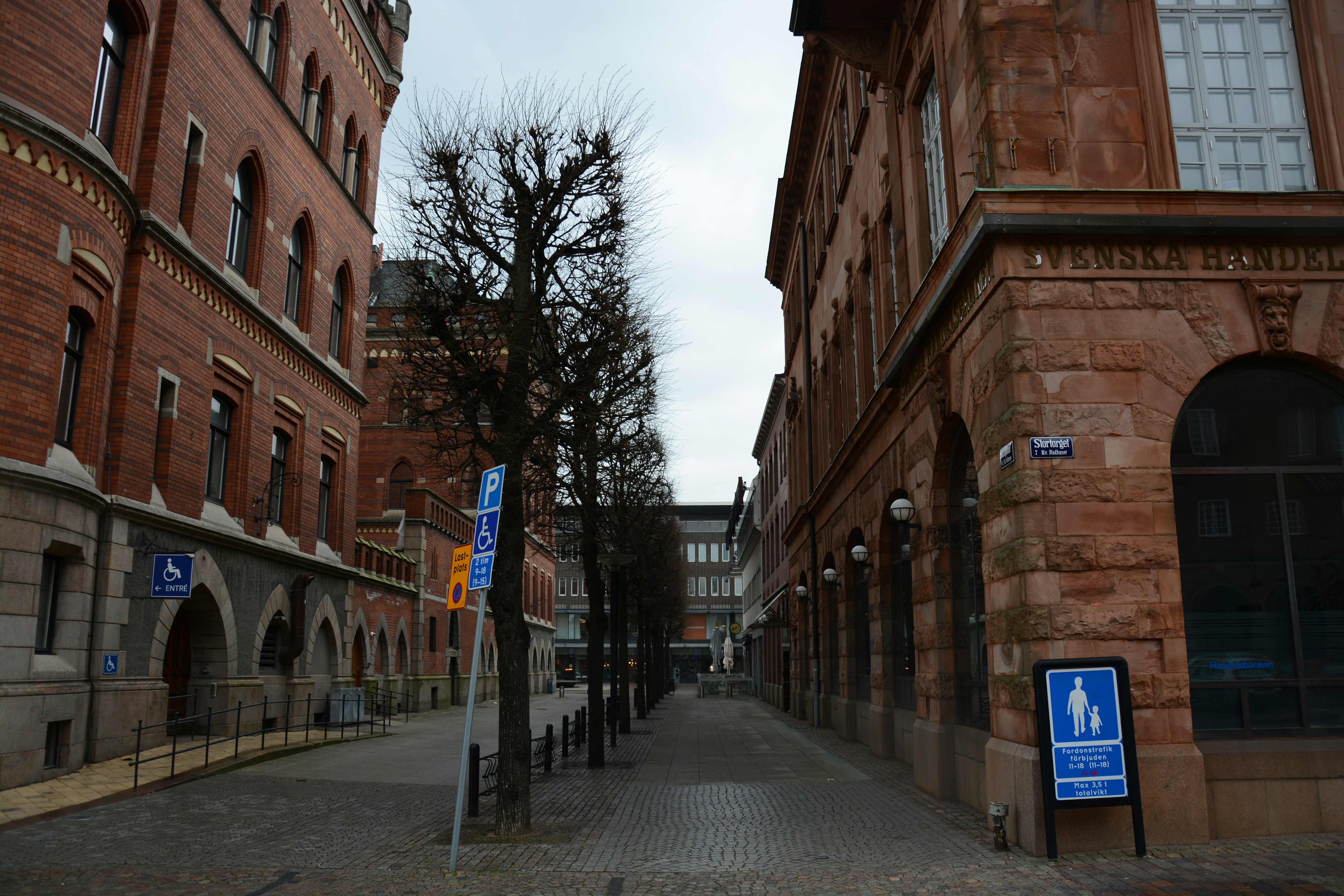 A narrow city street lined with tall brick buildings photo – Free City ...
