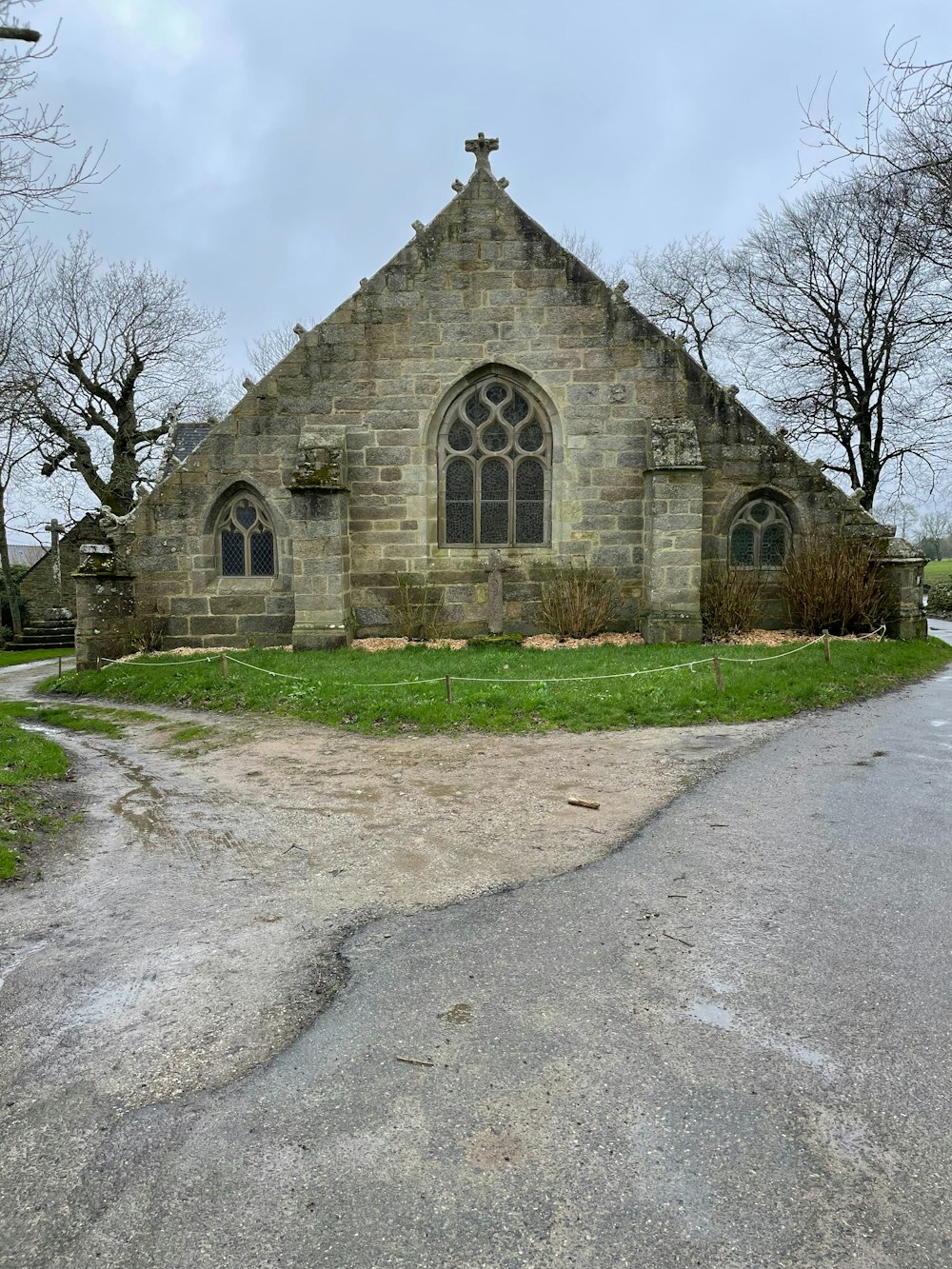 an old stone church with a cross on the front