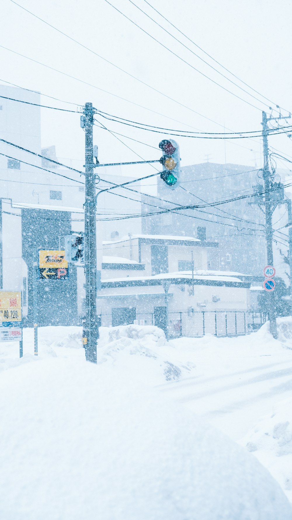 a traffic light in the middle of a snowy street