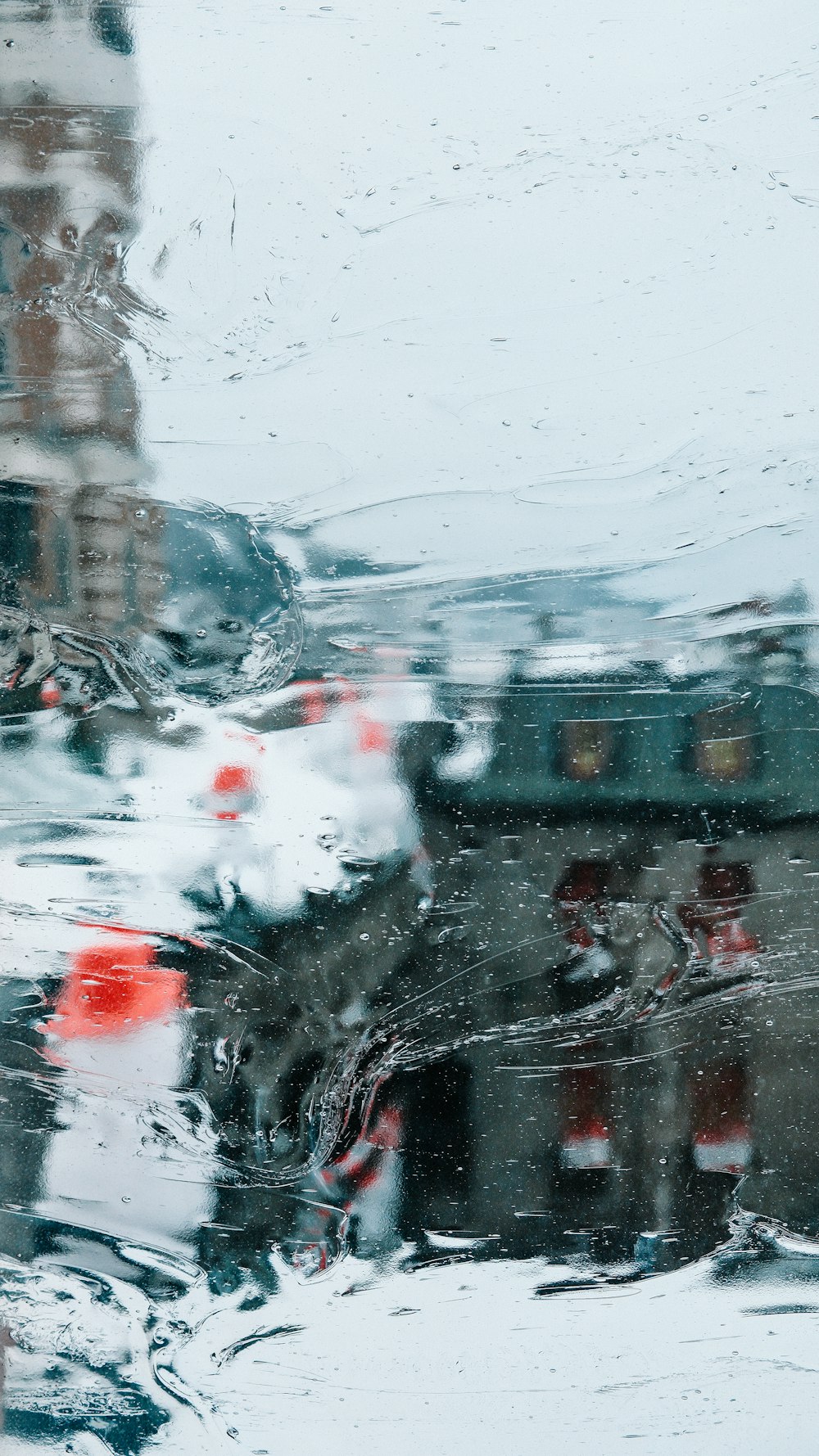 a view of a building through a rain covered window