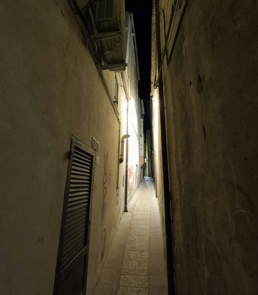 a narrow alley way with a door and shutters