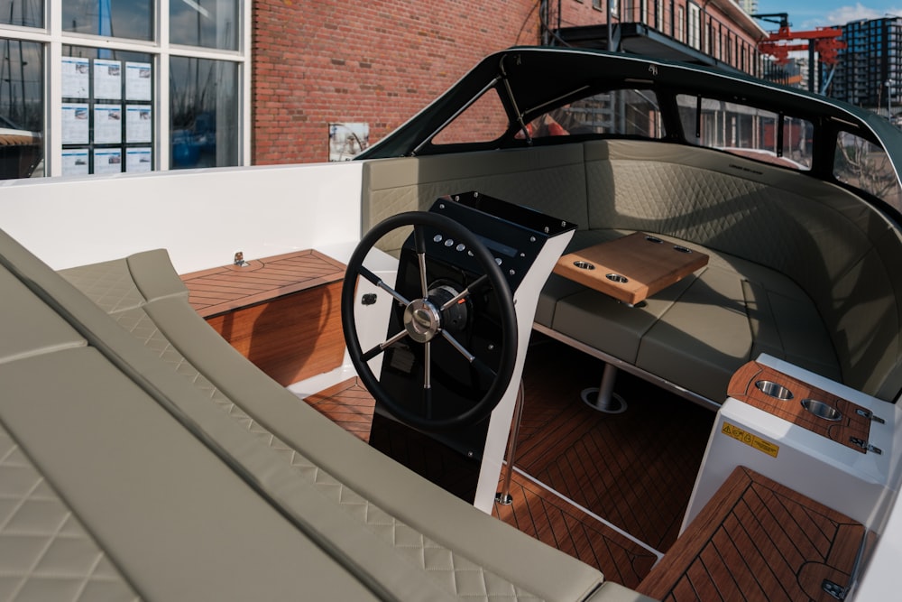 a boat with a steering wheel and a wooden deck