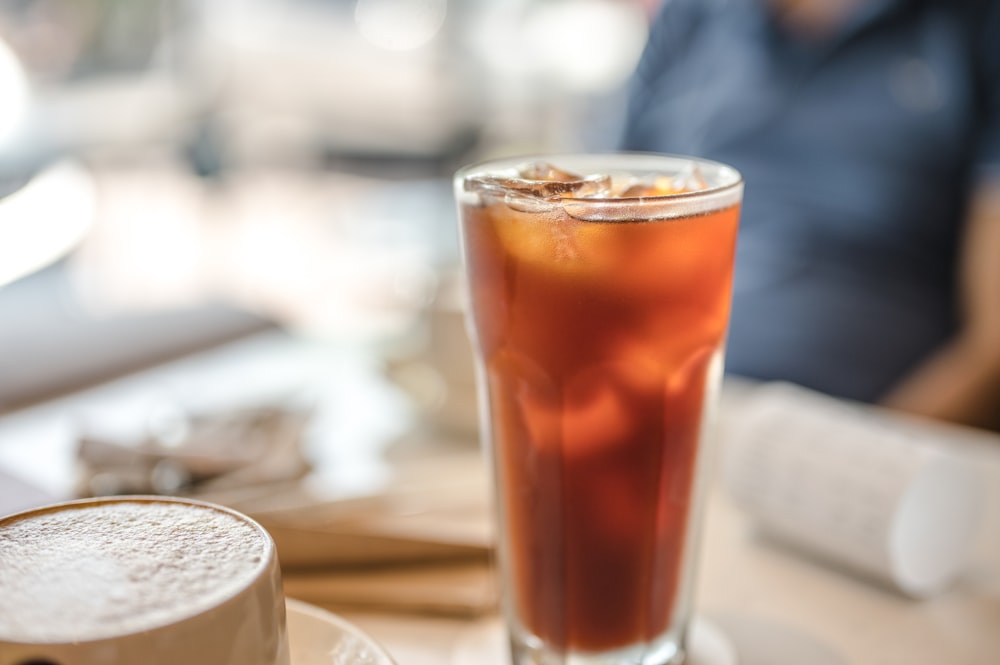 a glass of tea and a cup of coffee on a table