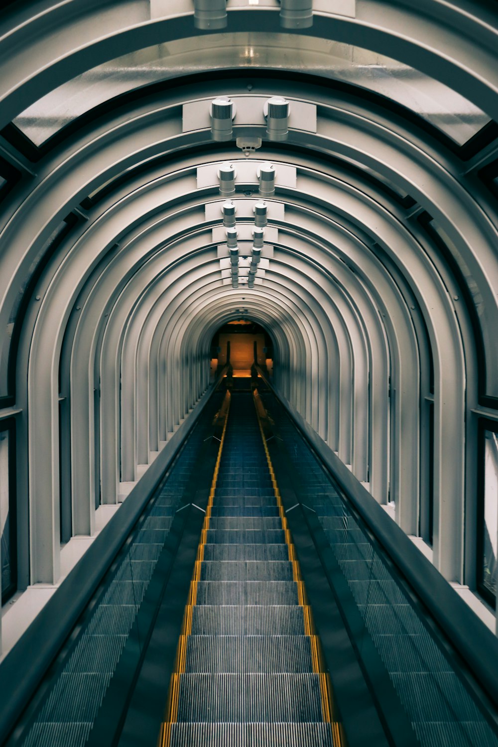 an escalator going down the middle of a tunnel