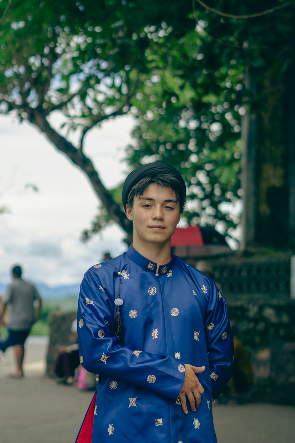 a man in a blue outfit standing on a sidewalk