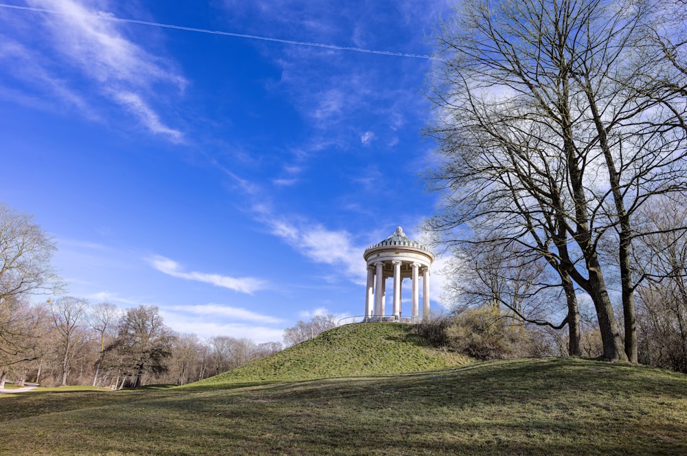 a small white tower on top of a hill