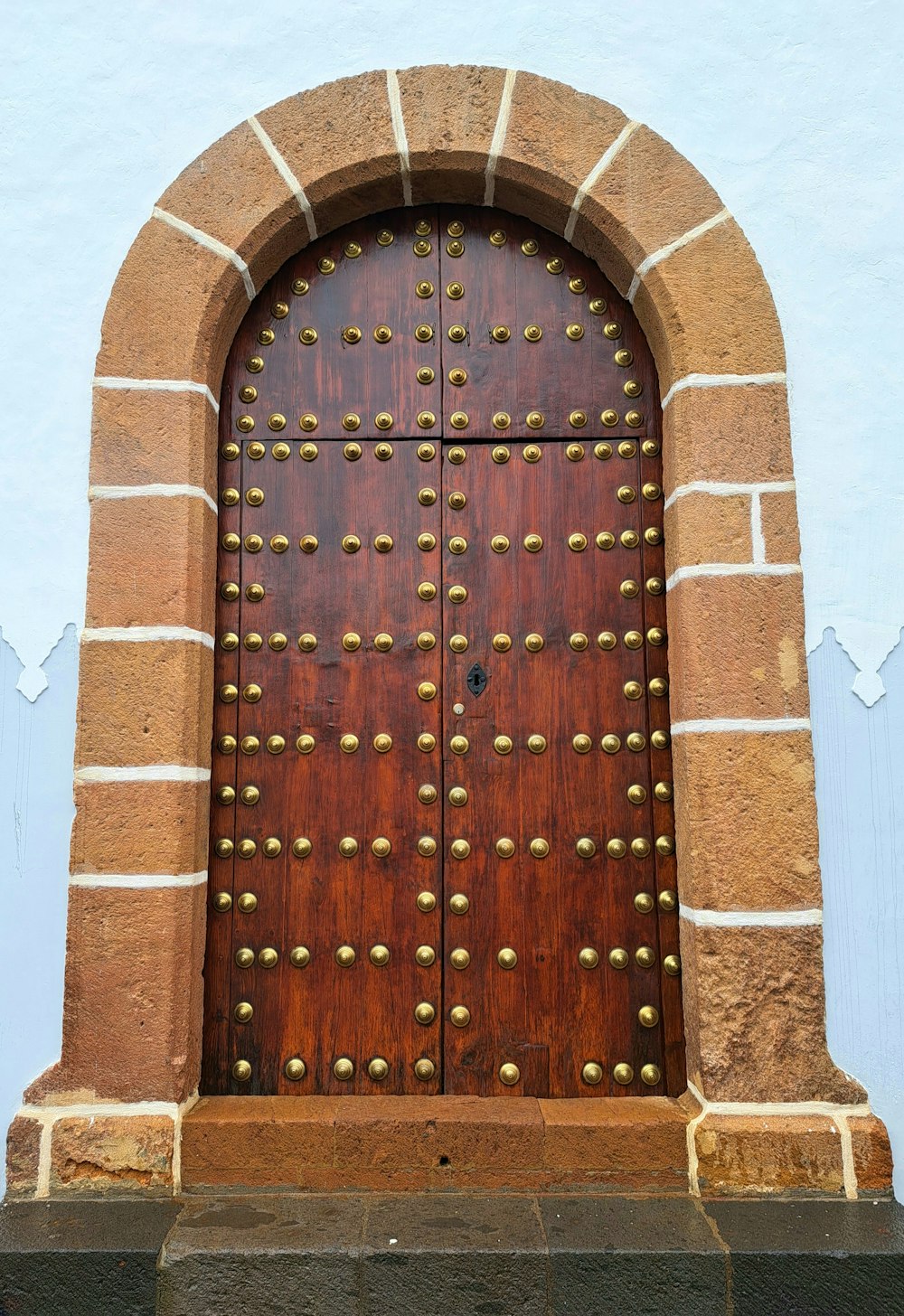a large wooden door with metal studs on it