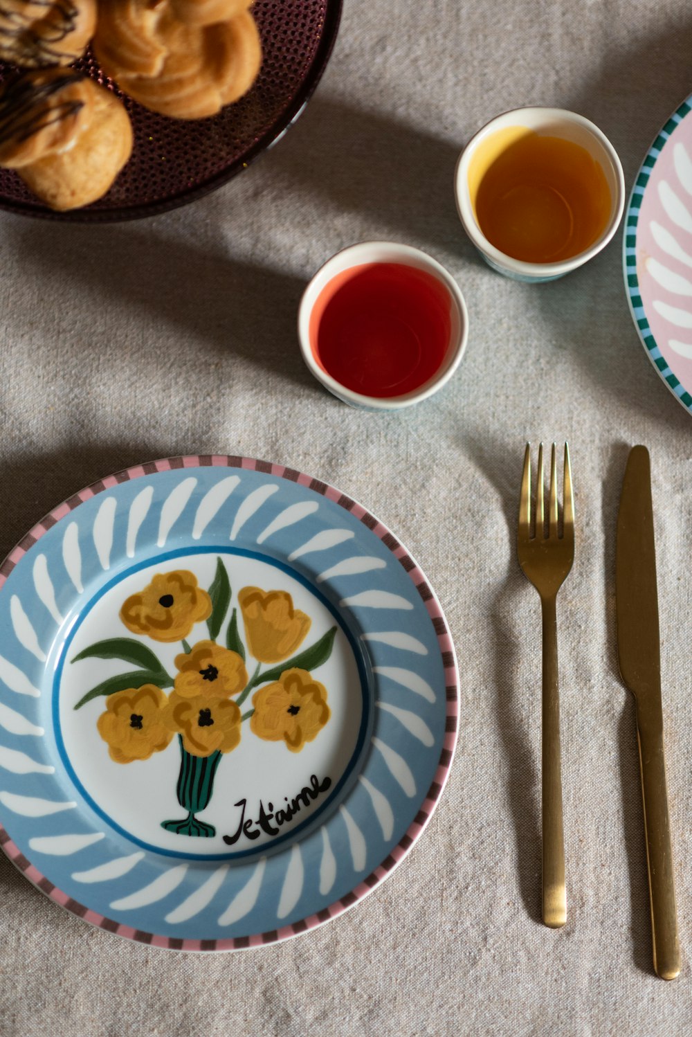 a table topped with plates and cups filled with food