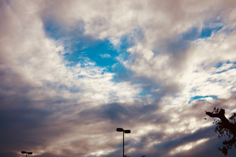 a sky filled with clouds and a street light