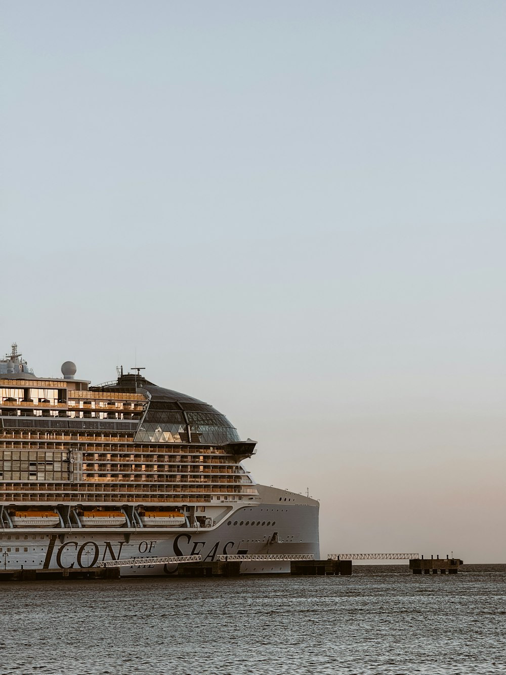 a large cruise ship in the water next to a dock