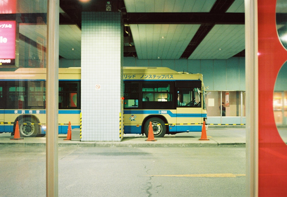 a yellow and blue bus parked inside of a building