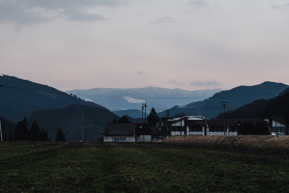 una casa in un campo con le montagne sullo sfondo