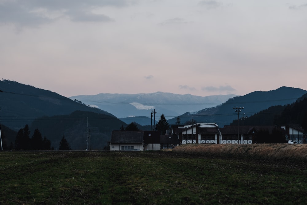 a house in a field with mountains in the background