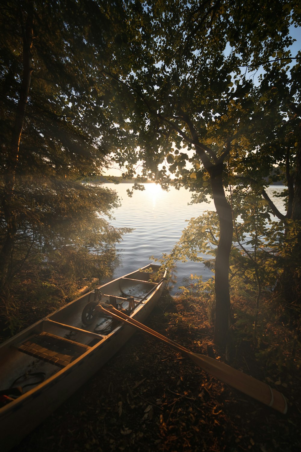 two canoes sitting on the shore of a lake