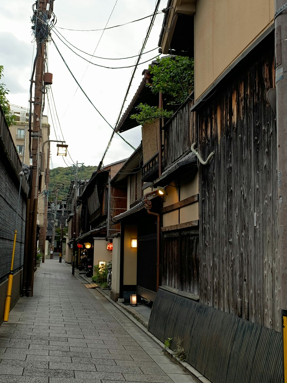 a narrow street with a wooden building on the side