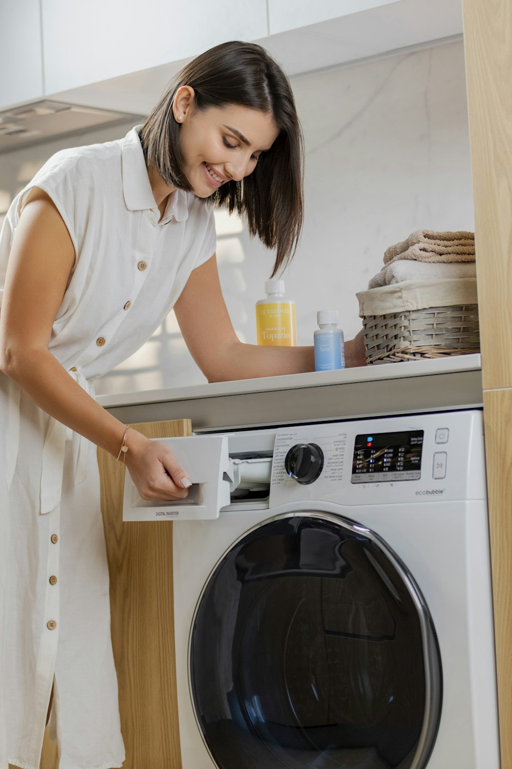 a woman is putting something in a washing machine