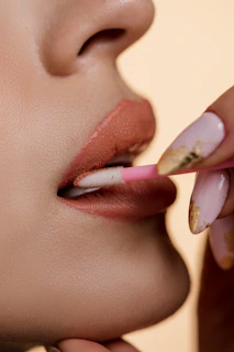 a woman is putting lipstick on her lips