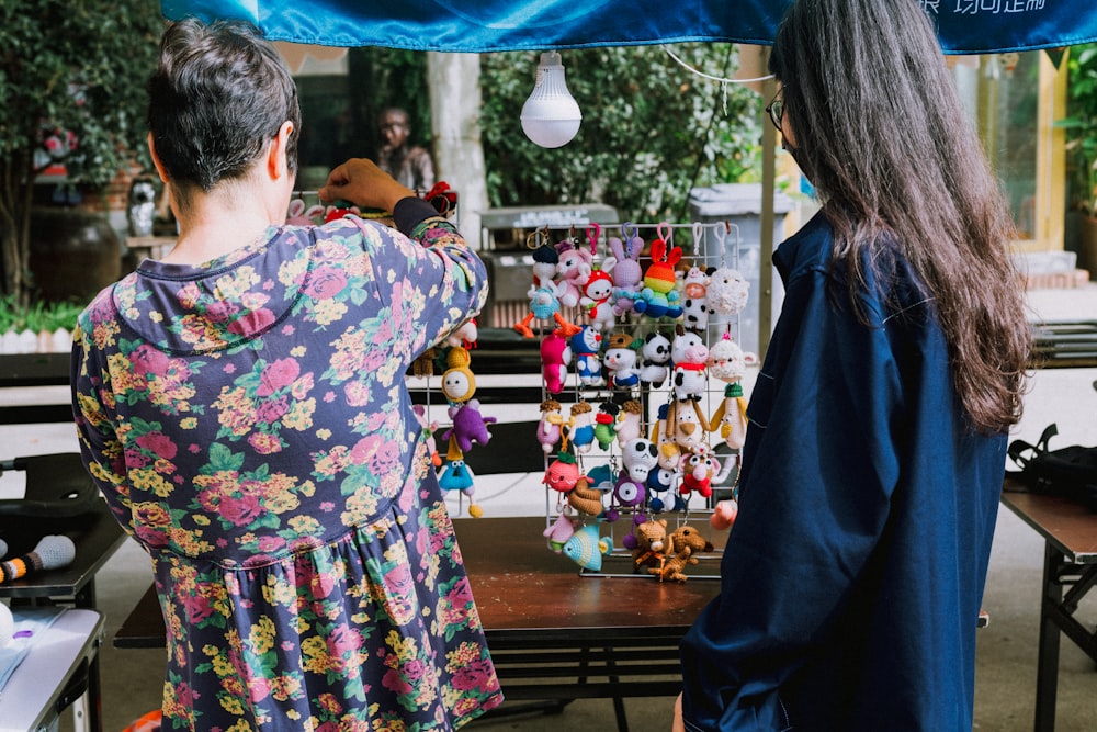 a man and a woman looking at a display of stuffed animals