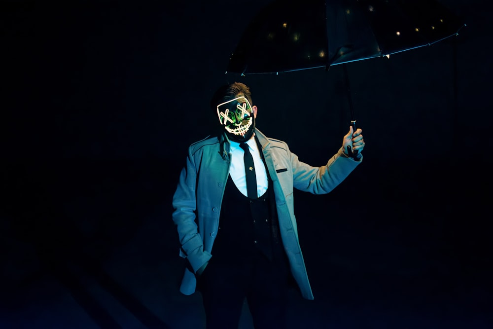 a man in a suit and mask holding an umbrella