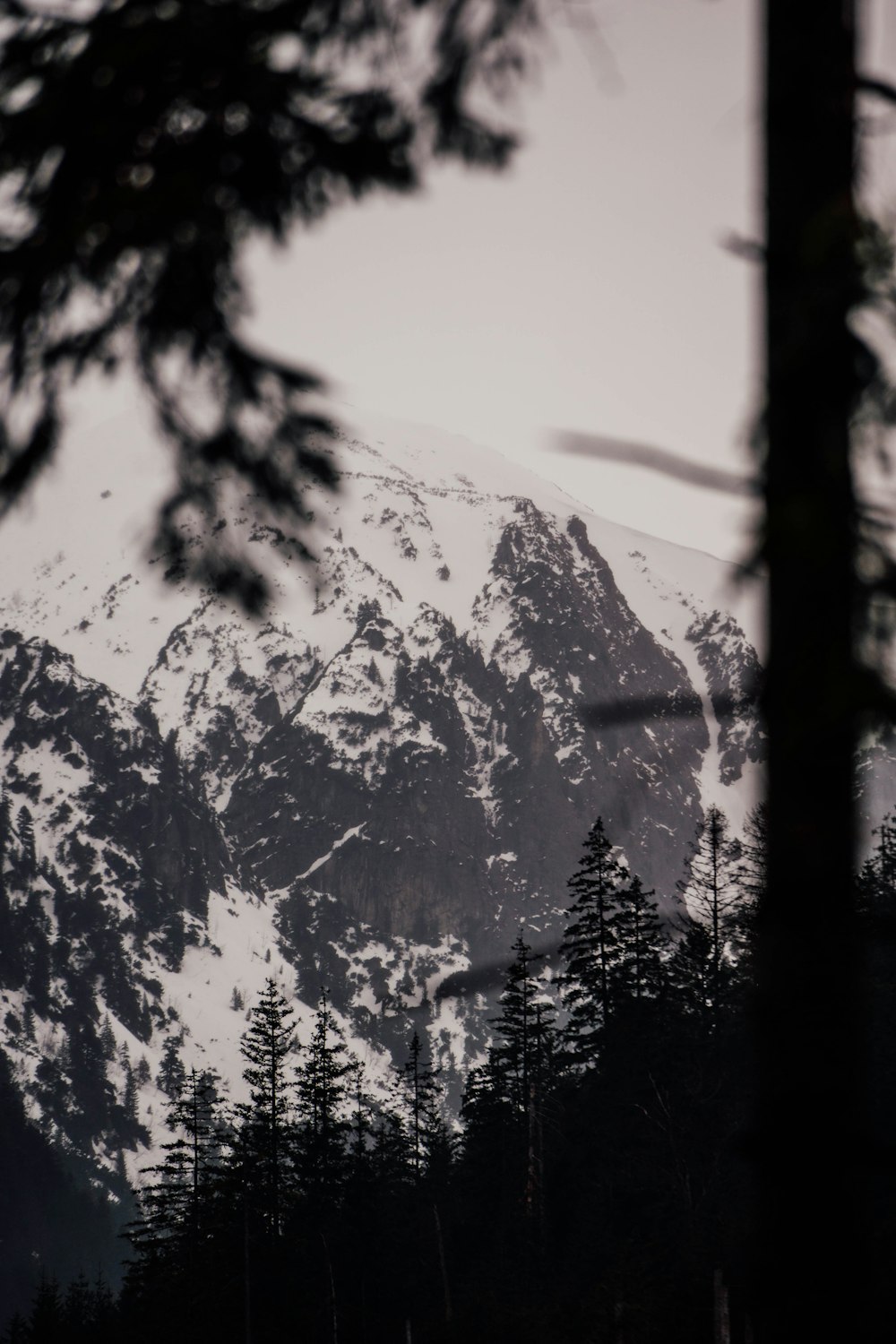 a snow covered mountain is seen through a window