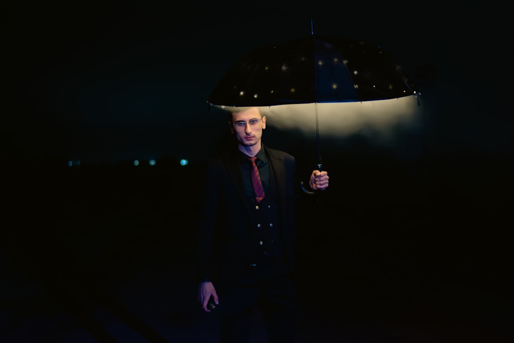 a man holding an umbrella in the dark