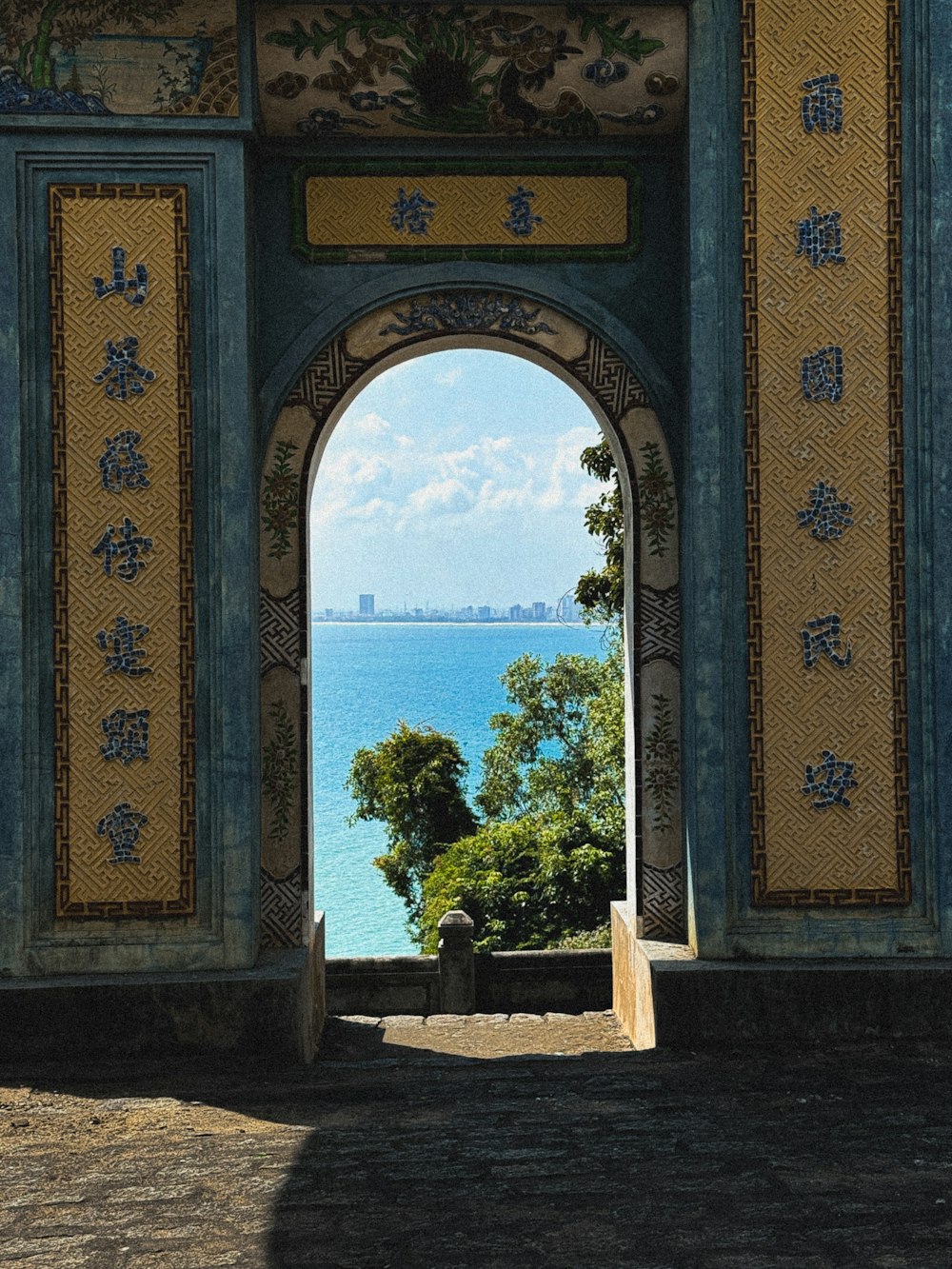 an archway with a view of a body of water