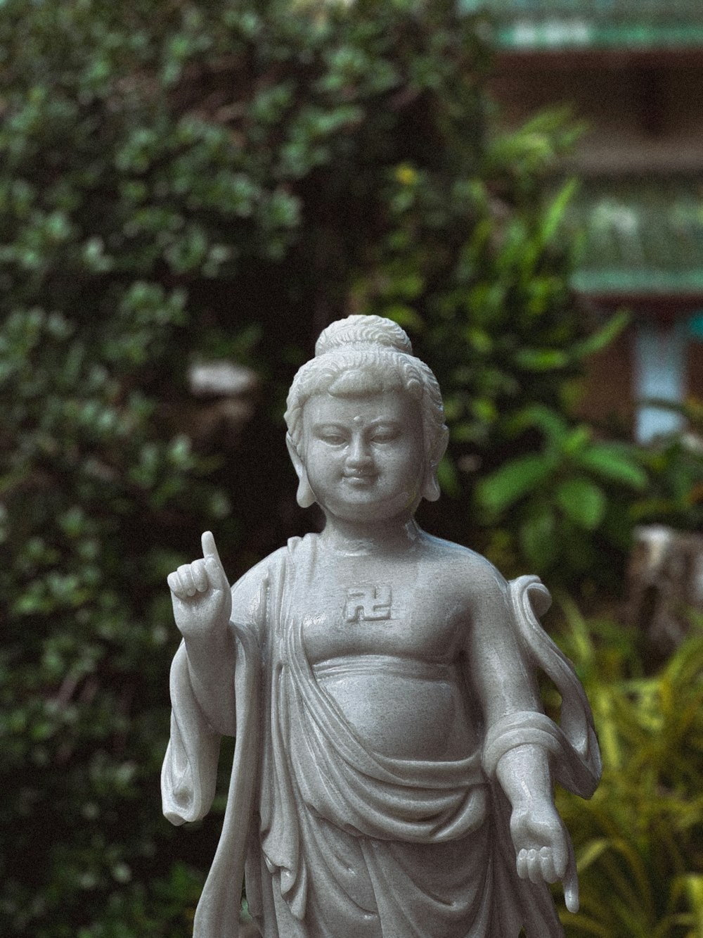 a statue of a buddha holding a peace sign