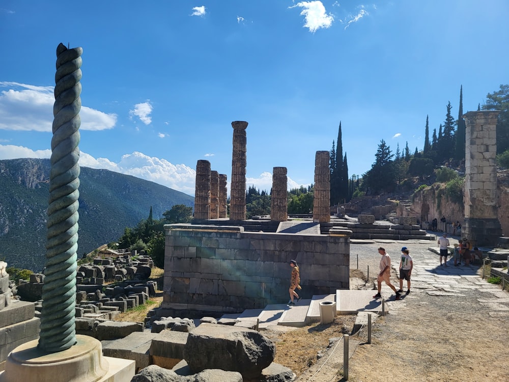 a group of people walking around a stone structure