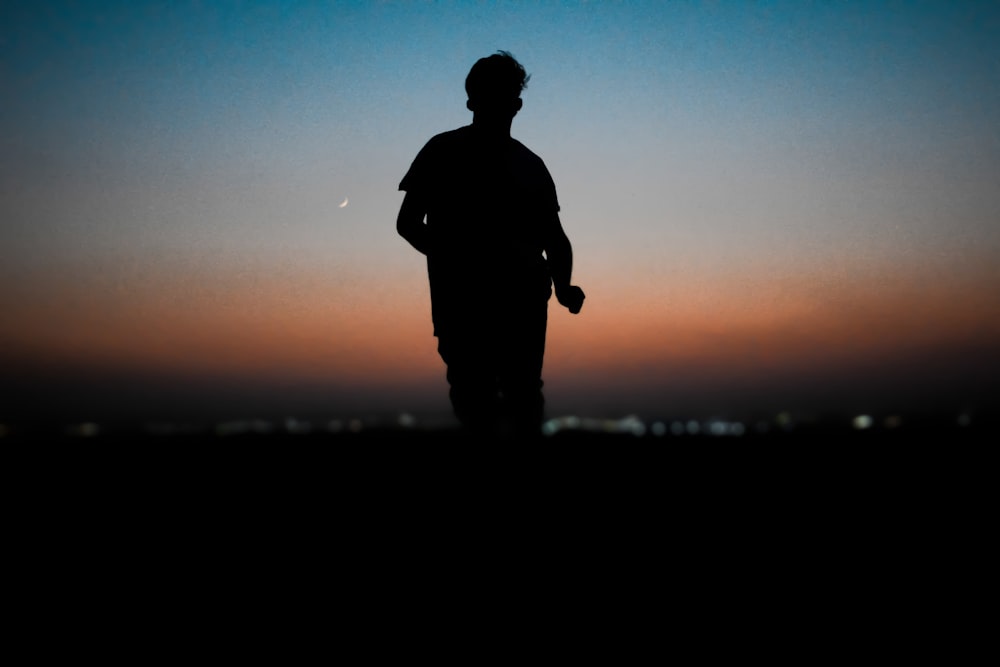 a silhouette of a man standing in the dark