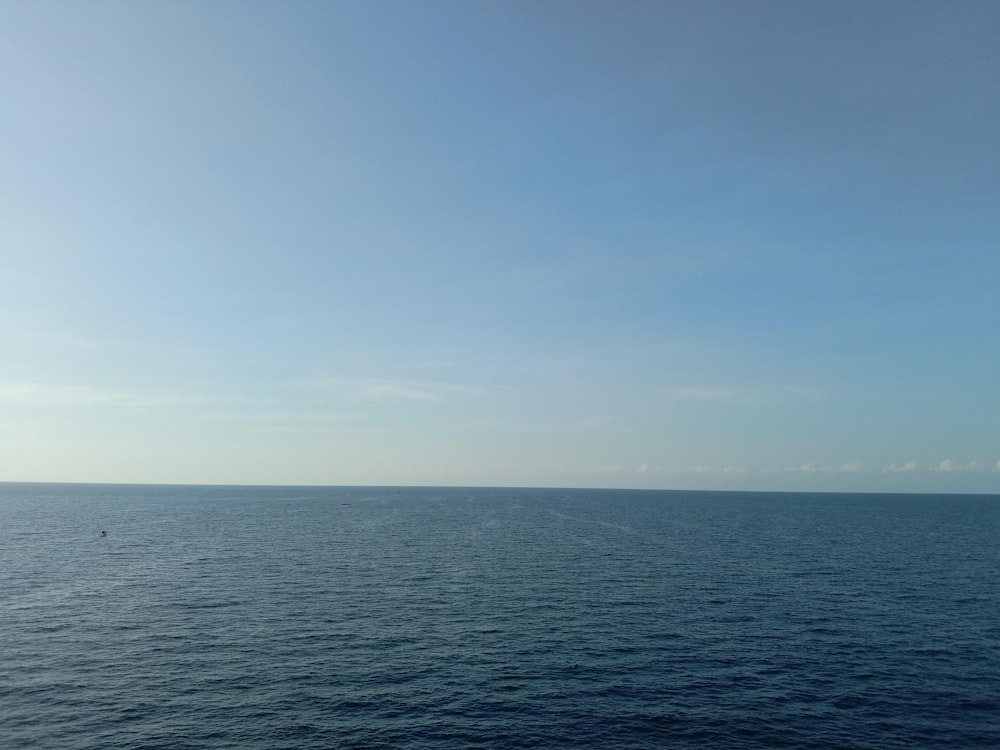 a large body of water sitting under a blue sky