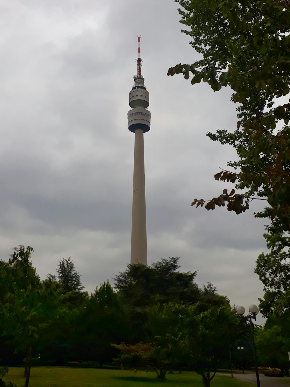 una torre muy alta que se eleva sobre un exuberante parque verde