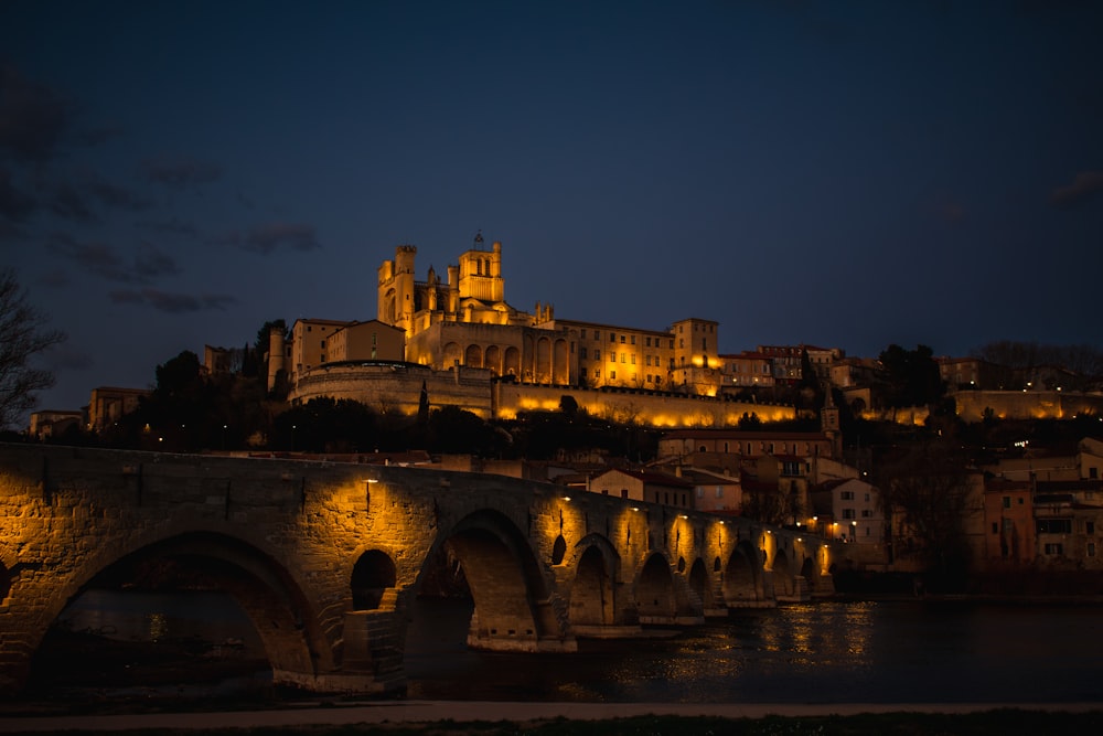 a castle lit up at night over a river