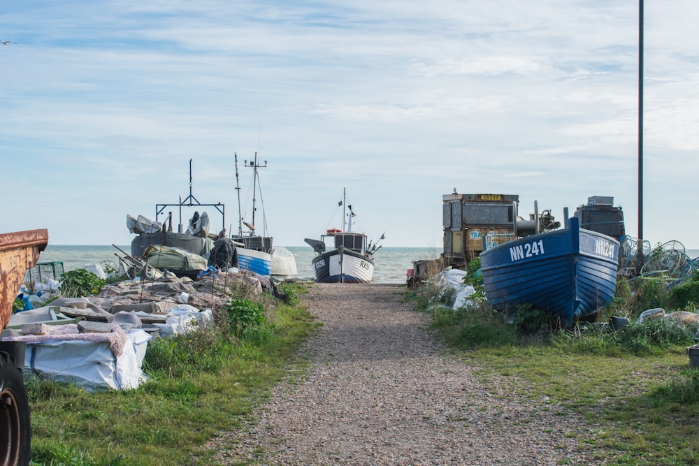 a couple of boats that are sitting in the grass