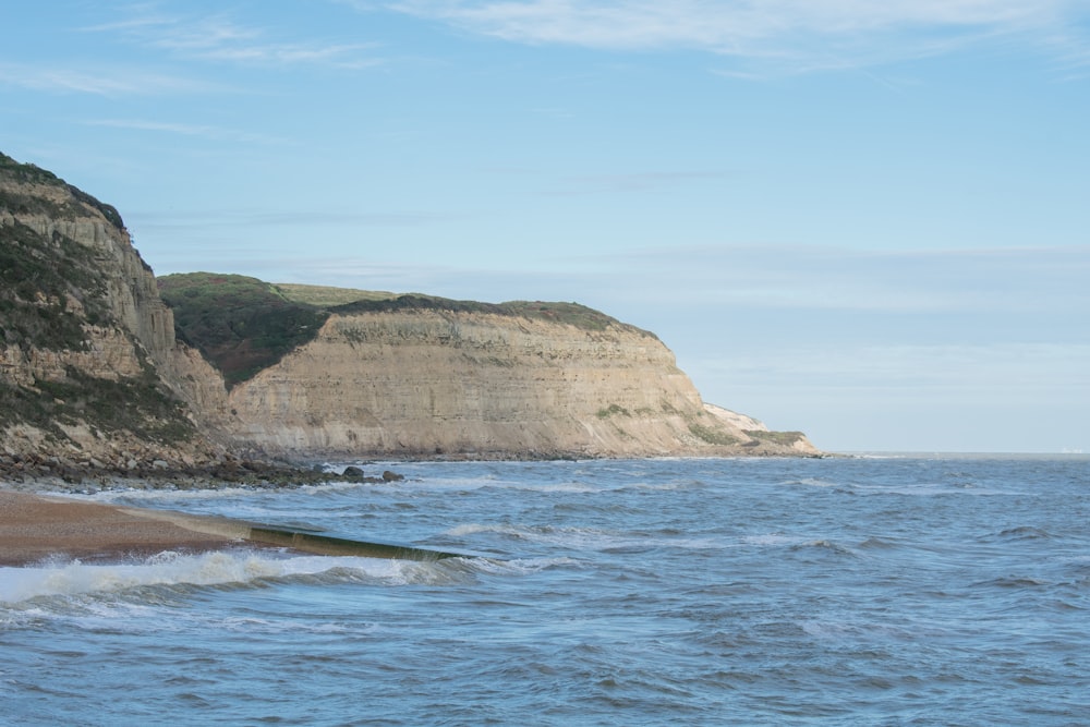 a large body of water next to a rocky cliff