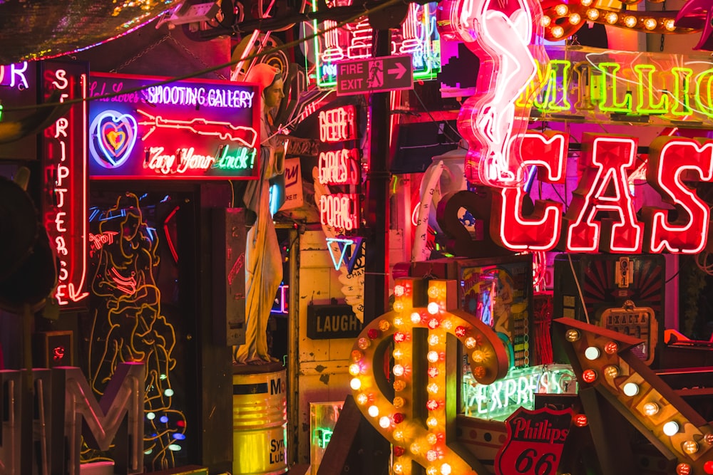 a bunch of neon signs that are on the side of a building