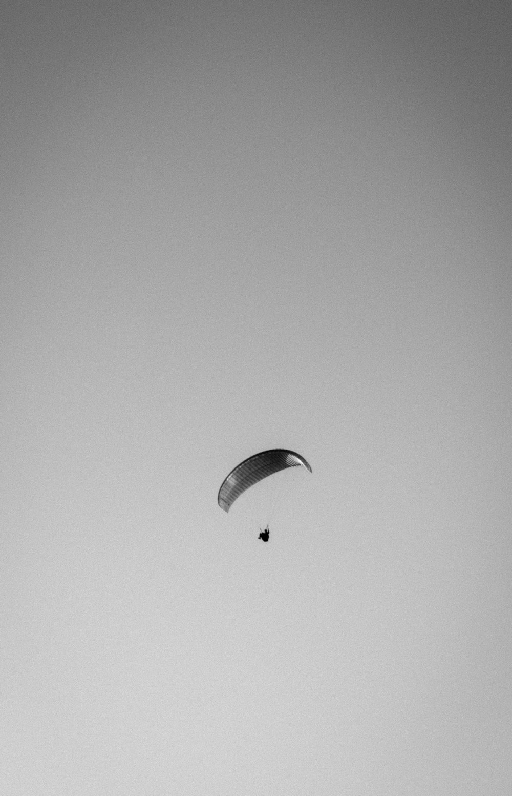 a paraglider is flying high in the sky