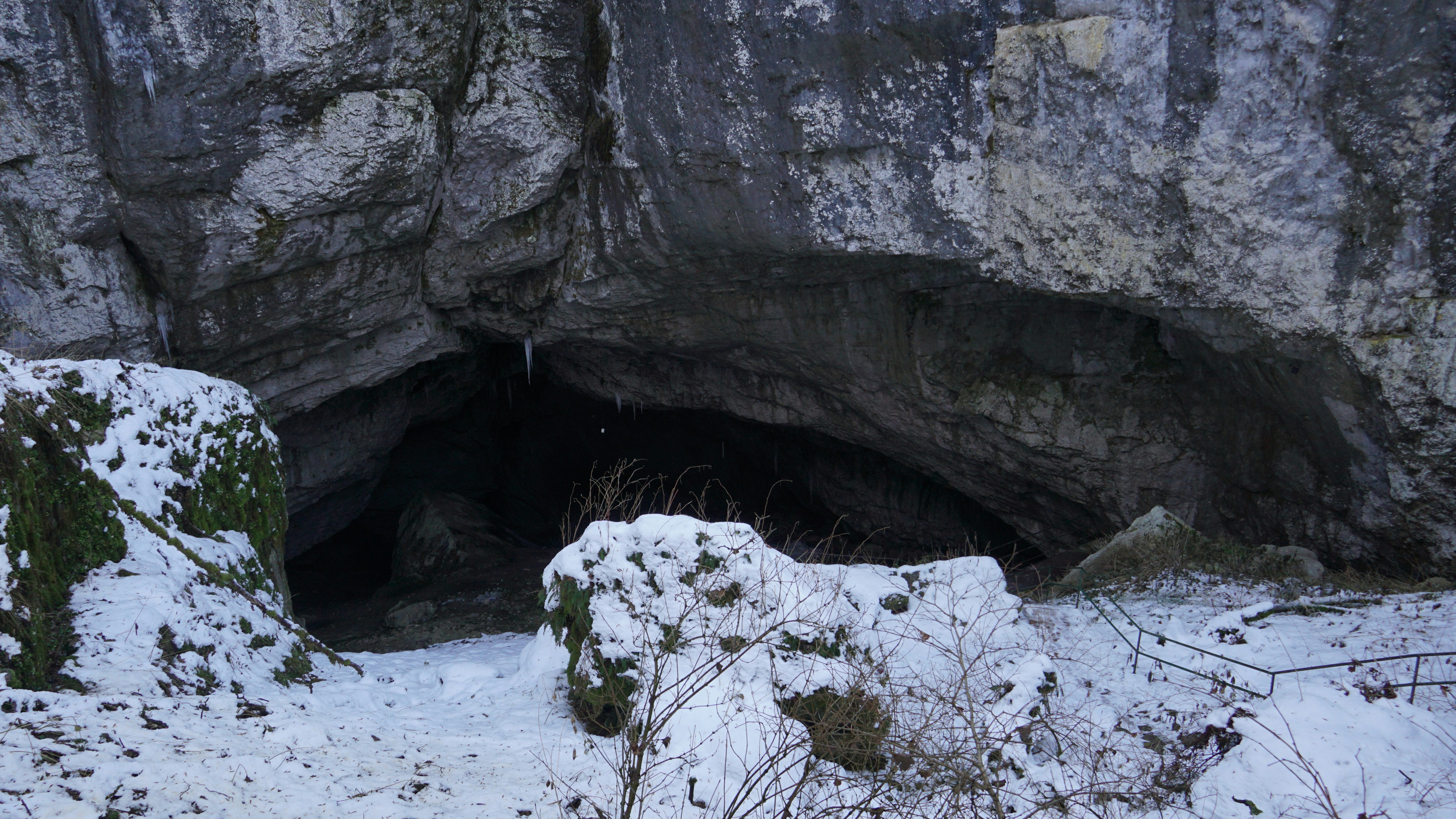 a snow covered area with a cave entrance