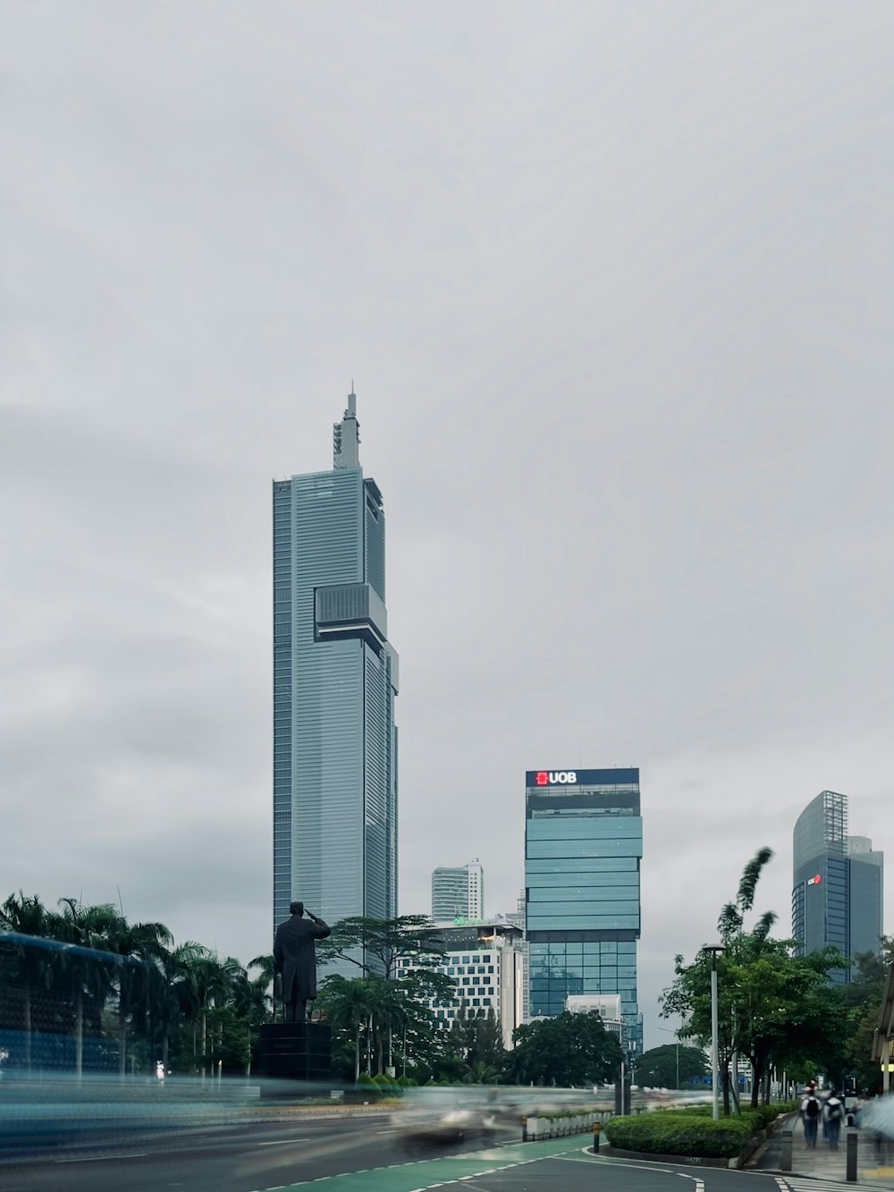 a city street with tall buildings in the background