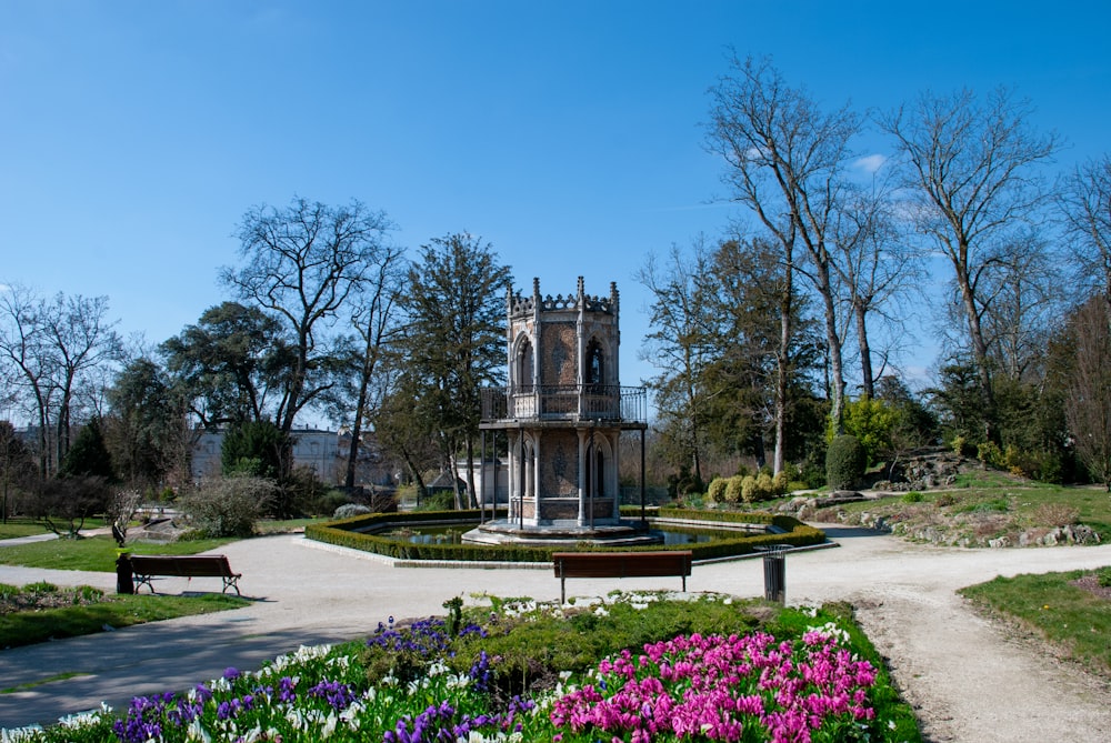 a garden with flowers and a building in the background