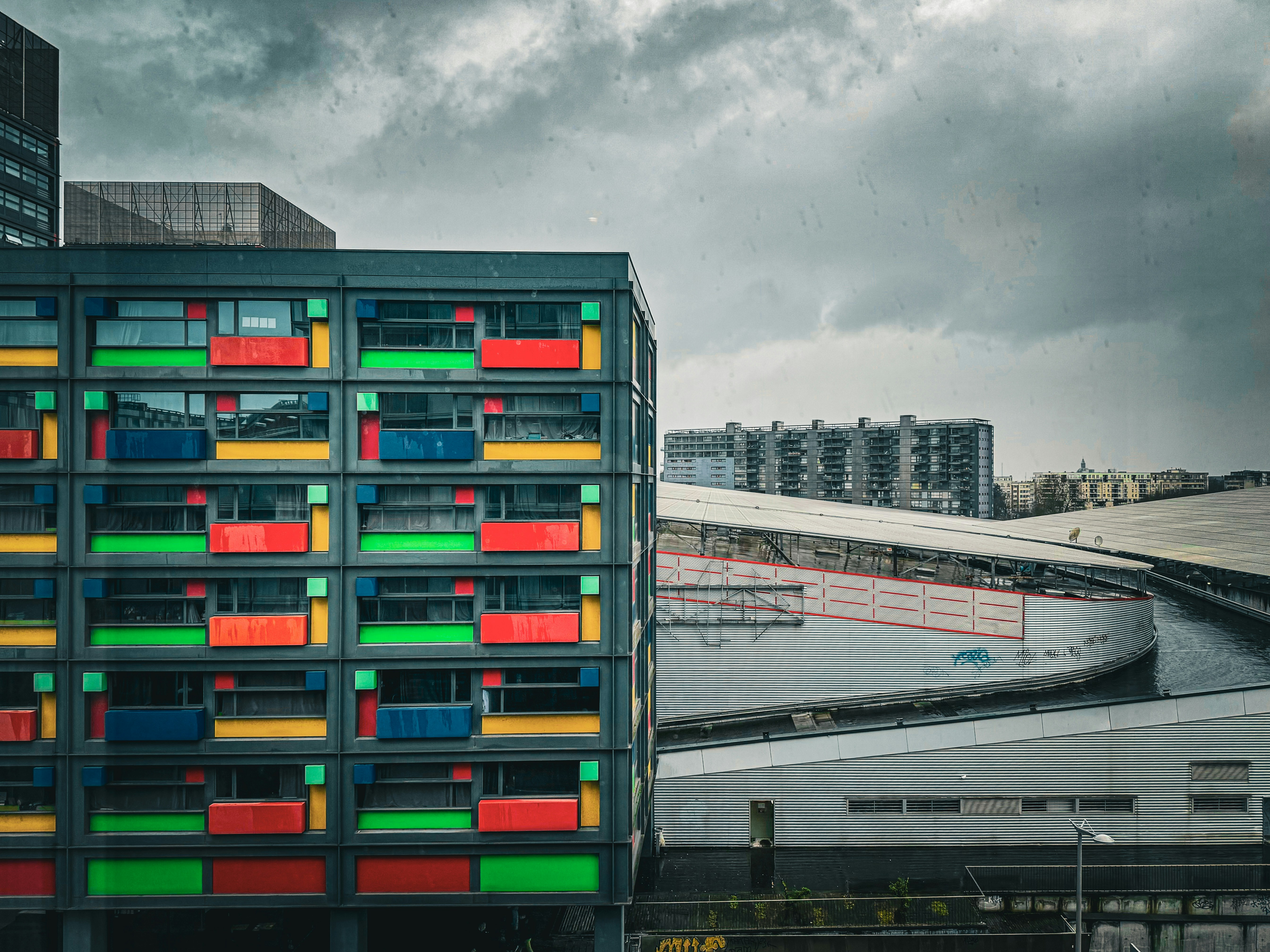 Un bâtiment multicolore à côté d’un plan d’eau