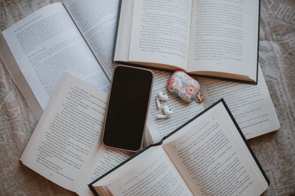 a table topped with open books and a cell phone